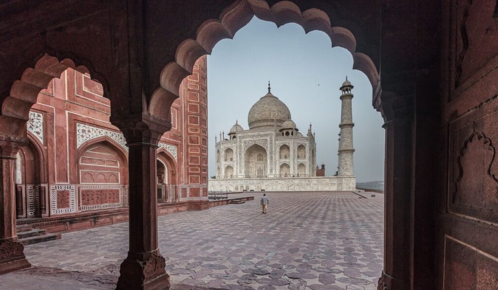 Taj Mahal view through Mughal arch with peaceful morning atmosphere in Agra