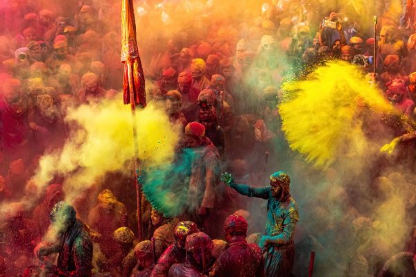 People celebrating Holi festival in India throwing colorful powder in a vibrant crowd